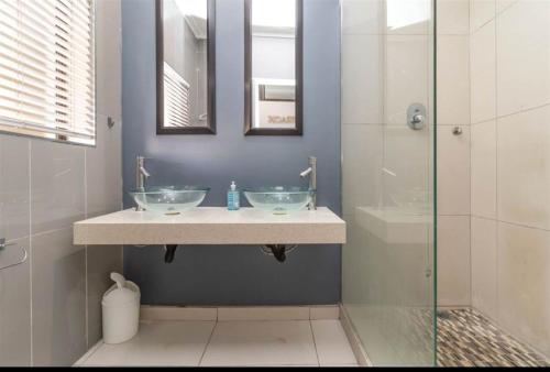 a bathroom with two sinks and a shower at Cabanas Del Mar 32 in Kingsburgh