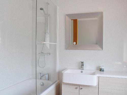 a bathroom with a shower and a sink and a mirror at Lyndhurst in Ely