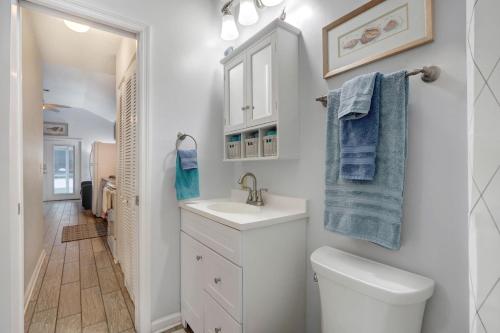 a white bathroom with a sink and a toilet at EZBreezy - 4217 Fifth Street in Saint Simons Island