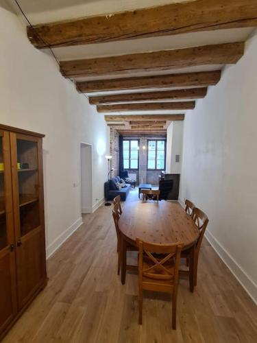 un salon avec une table et des chaises en bois dans l'établissement Elégant 2 chambres vieille ville, à Besançon