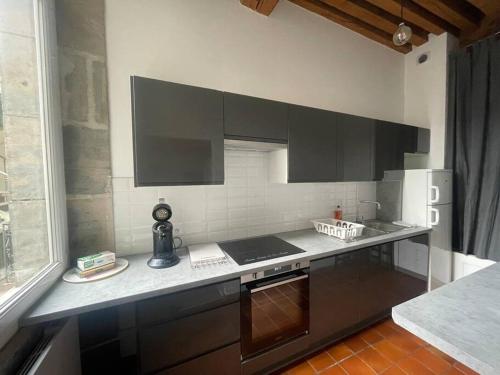 a kitchen with black cabinets and a counter top at Elégant 2 chambres vieille ville in Besançon