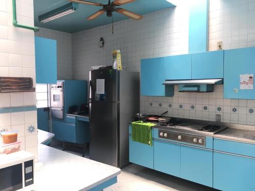 a kitchen with blue cabinets and a black refrigerator at Casa Alsacia in Guadalajara