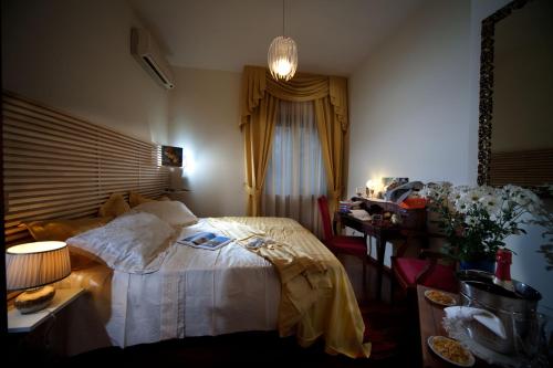 a bedroom with a bed and a desk and a table with a lamp at Napoli Porta Di Mare in Naples
