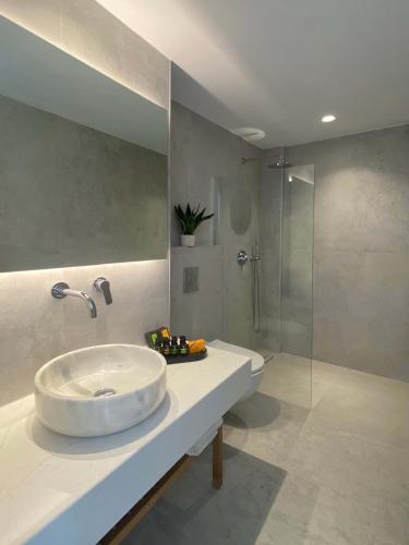 a bathroom with a sink and a shower at Calistus Mykonos in Mikonos