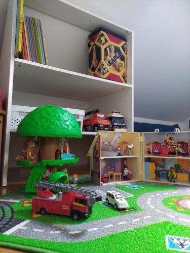 a shelf with a toy house and a toy truck at L'essentiel, proche de Disneyland Paris 2 chambres et 2 SDB in Chessy