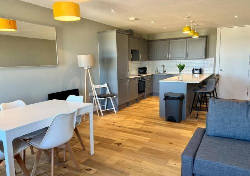 uma cozinha e uma sala de estar com mesa e cadeiras em Margate Seaside Penthouse With Sea views Sleeps 6 em Kent