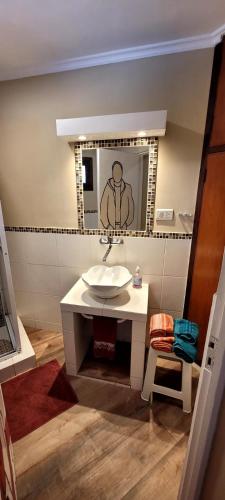 a bathroom with a sink and a mirror at Casa 24 Puerto Iguazu in Puerto Iguazú