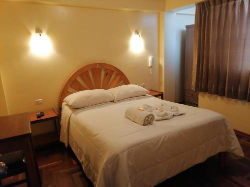 1 dormitorio con 1 cama grande y toallas. en Suyay B&B en Cuzco