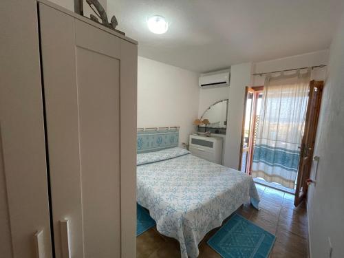 - une petite chambre avec un lit et une fenêtre dans l'établissement Le Onde, à Torre Dei Corsari