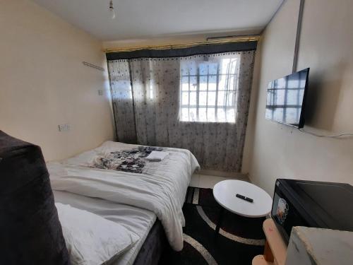 a small room with a bed and a window at Sweet Memories Haven in Kikuyu