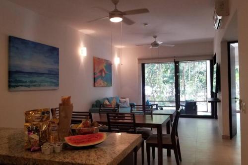 a dining room and living room with a table and chairs at TAO Garden Luxury Condo in Akumal