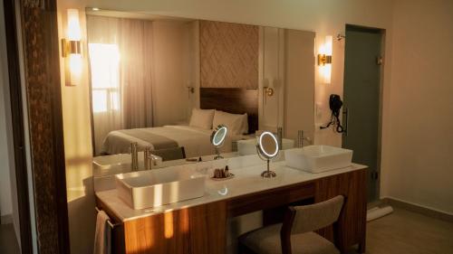 une salle de bains avec deux lavabos et un lit dans l'établissement Casa Maria Boutique Hotel, à San Carlos