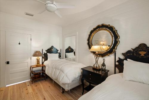a bedroom with two beds and a mirror on the wall at Endless Summer - 4217 - 6th Street in Saint Simons Island
