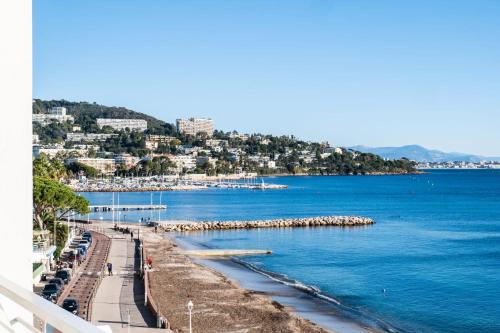 widok na plażę z błękitną wodą i miasto w obiekcie PANORAMIC SEA VIEW Apartment in the Mourré Rouge area of Cannes w Cannes