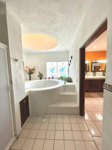 a large bathroom with a tub and a sink at Casa con Piscina Cerca de playa in Nuevo Vallarta