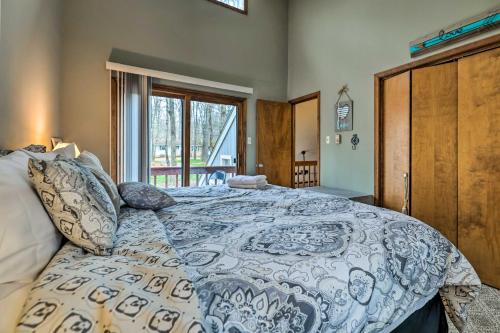 um quarto com uma cama com um edredão azul e branco em Poconos Vacation Home Walk to Locust Lake! em Pocono Lake