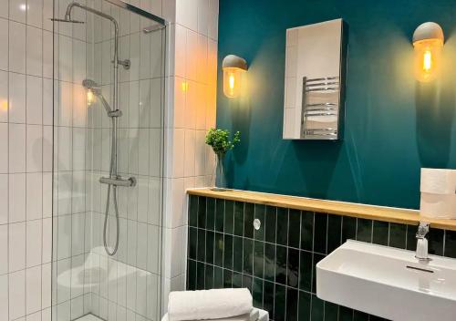 a bathroom with a shower and a sink at Beachfront Bliss Margate With Sea Views Sleeps 7 in Kent