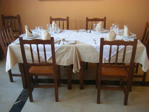 a dining room table with a white table cloth and chairs at Hotel Mirador in Algeciras