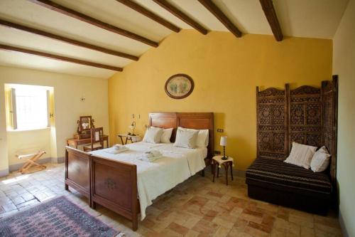 sypialnia z dużym łóżkiem i krzesłem w obiekcie Il casale tra le vigne e il mare w mieście Tollo