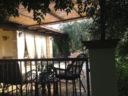 a patio with a table and chairs under a pergola at Il casale tra le vigne e il mare in Tollo