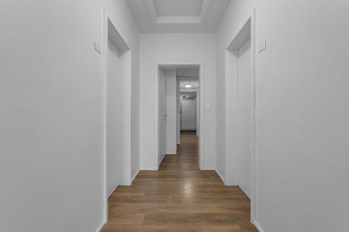 an empty hallway with white walls and wooden floors at Bank Guesthouse by KEF Airport in Keflavík
