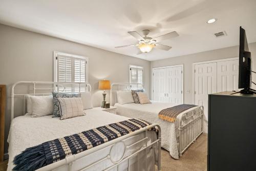 ein Schlafzimmer mit zwei Betten und einem Deckenventilator in der Unterkunft Village Retreat - 100 Mews Circle in King City