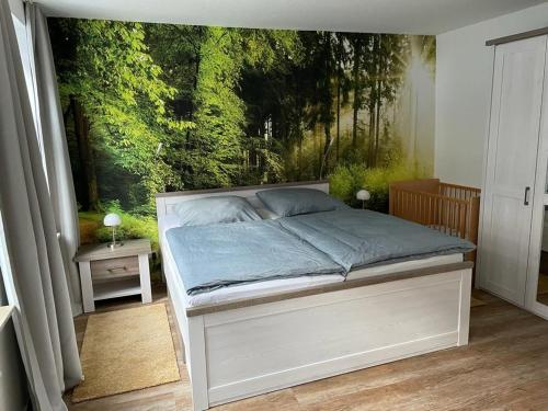 a bedroom with a bed with a painting on the wall at Ferienhaus Harzcolor Wernigerode in Wernigerode