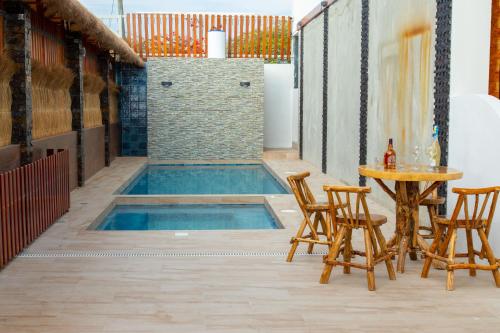 阿揚奎的住宿－HOTEL SEAHORSE AYANGUE，庭院中间的游泳池,配有椅子和桌子