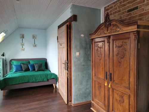 a bedroom with a bed and a wooden cabinet at DOM GOŚCINNY PTASZARNIA - NATURA-Free PARKING in Świnoujście