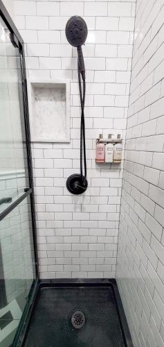 a shower with a black hose in a bathroom at Amsterdam Hostel in San Francisco