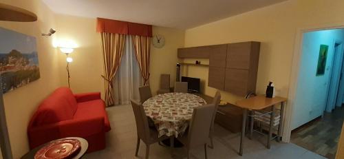 sala de estar con mesa y sofá rojo en Dimora Tipica Appartamento, en Sestri Levante