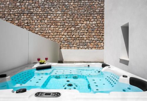 wanna z hydromasażem w pokoju ze ścianą kamienną w obiekcie Villa Oro w mieście Salobreña