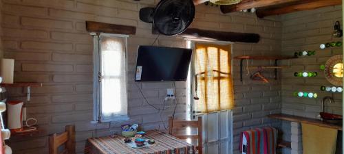 a room with a table and a tv on a wall at La Arenosa in Cafayate