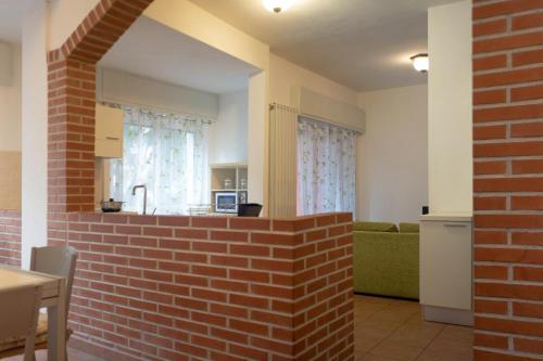 een woonkamer met een bakstenen muur en een keuken bij Caprice Appartamenti Vacanze in Diano Marina