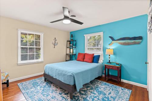1 dormitorio con cama y pared azul en Lega-Sea 4210 Tenth Street East, en Saint Simons Island