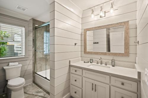 a bathroom with a toilet and a sink and a mirror at Viewpoint Oaks - 301 7th Street, Unit 101 in Saint Simons