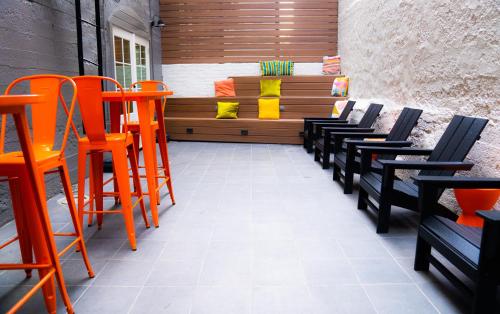 a patio with orange chairs and a bench at Amsterdam Hostel in San Francisco