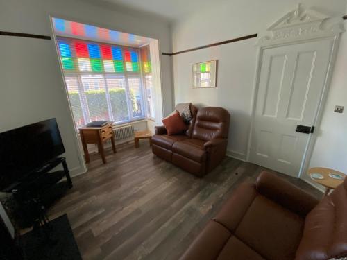 a living room with a couch and a chair and a window at Cosy 2 Bedroom House -2023, 2024 &2025 award winner! in Ramsgate