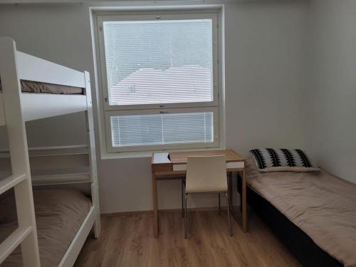um quarto com uma secretária, uma cama e uma janela em Levinlaita em Levi