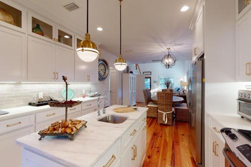 - une cuisine avec des placards blancs et un comptoir avec un évier dans l'établissement Coastal Comfort - 108 Fish Fever Lane, à Saint Simons