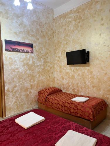 a small room with a bed and a flat screen tv at Rose Village Guest House in Rome