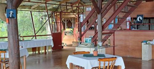 ein Zimmer mit Tischen und Stühlen in einem Gebäude in der Unterkunft Pochotel in Turrialba