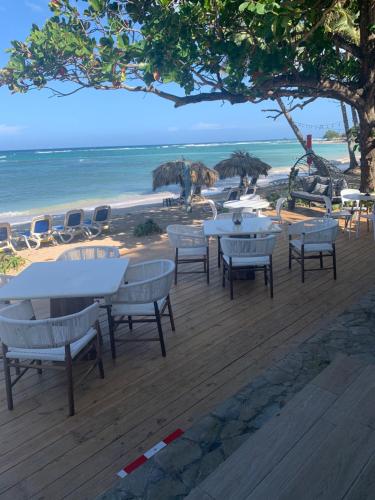 a group of tables and chairs on the beach at Mar azul 401 in San Felipe de Puerto Plata