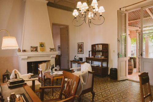 a living room with a fireplace and a chandelier at Casa de Aitona Bodega Zubizarreta in Carmelo