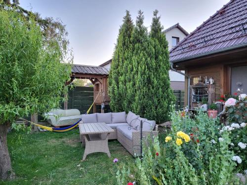 a garden with a couch and a hammock in the yard at DOM GOŚCINNY PTASZARNIA - NATURA-Free PARKING in Świnoujście