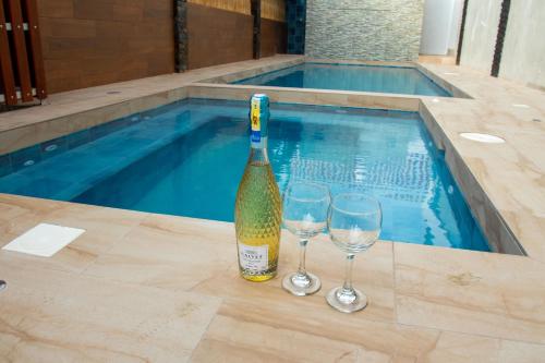 阿揚奎的住宿－HOTEL SEAHORSE AYANGUE，游泳池旁的一瓶香槟和两杯酒