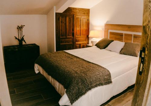 1 dormitorio con 1 cama grande en una habitación en El Aprisco, con piscina climatizada en Hueva-Guadalajara, en Hueva