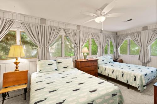 ein Schlafzimmer mit zwei Betten und einem Deckenventilator in der Unterkunft Crab Haven - 1137 Park Lane in East End