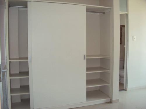 a closet with white walls and shelves at Selva Suites in Iquitos