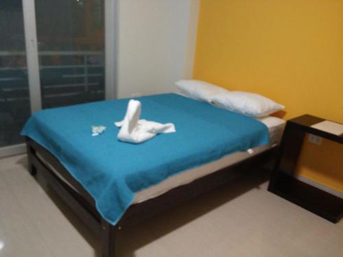 a bedroom with a bed with two white swans on it at Selva Suites in Iquitos
